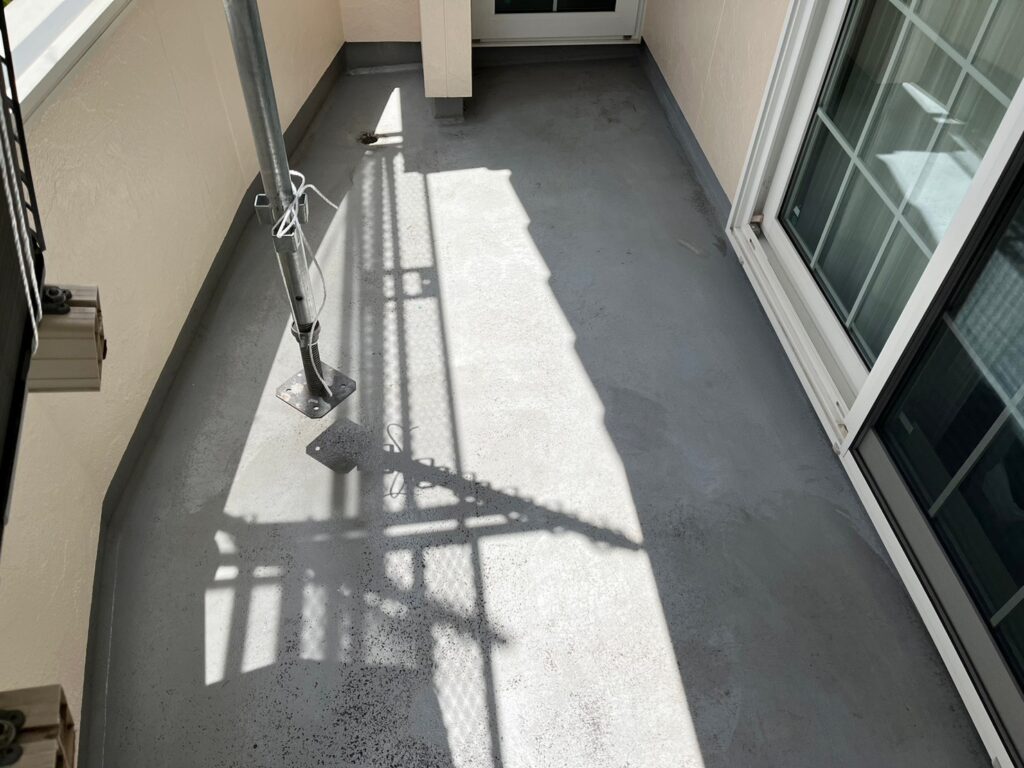 ベランダの防水が劣化し、水を弾かなくなっている様子の写真