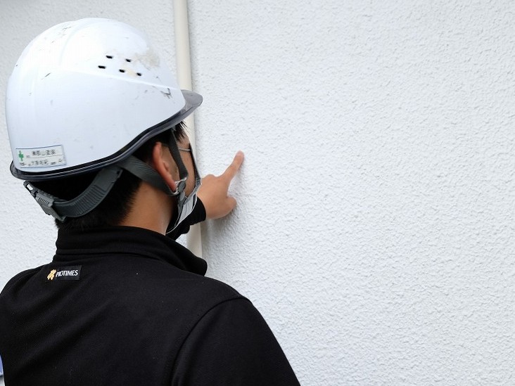 外壁塗装の現地調査で劣化状況を確認する様子