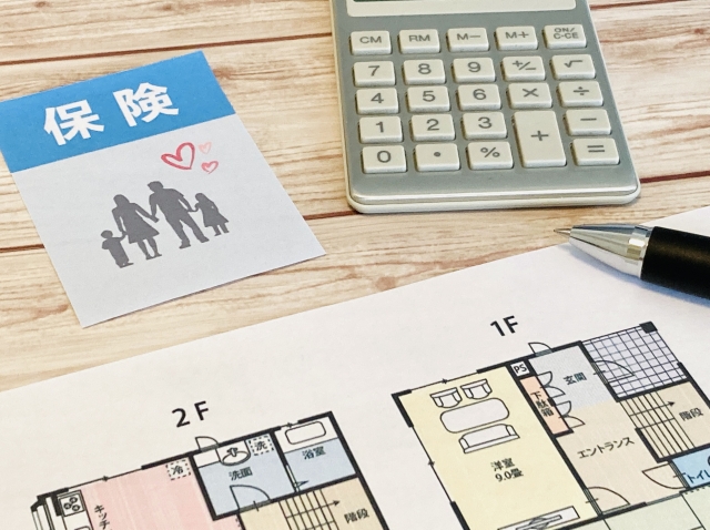 保険の文字と書類と電卓の画像