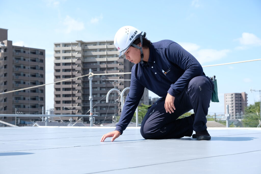 屋根の状態を確認しているスタッフの写真